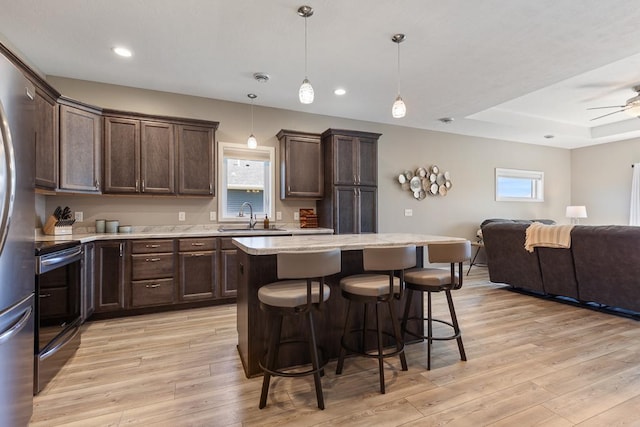 307 Brussels Ct, Marshall, MN 56258 - kitchen featuring stainless steel appliances, open floor plan, dark brown cabinets, a breakfast bar, and recessed lighting