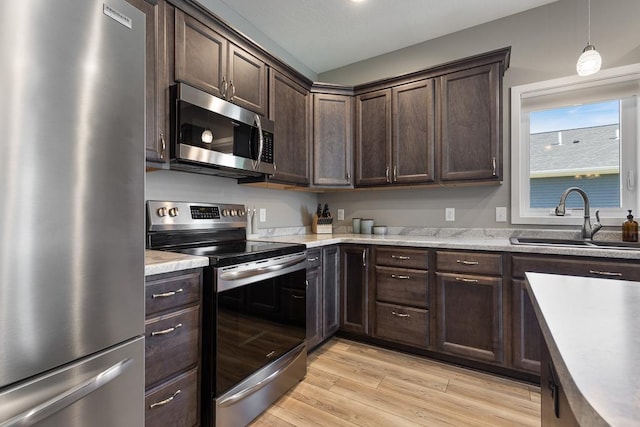 307 Brussels Ct, Marshall, MN 56258 - kitchen featuring appliances with stainless steel finishes, dark brown cabinets, light wood-style floors, light countertops, and pendant lighting