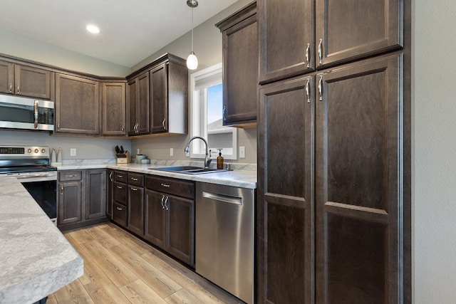 307 Brussels Ct, Marshall, MN 56258 - kitchen featuring appliances with stainless steel finishes, dark brown cabinetry, light wood-type flooring, light countertops, and pendant lighting