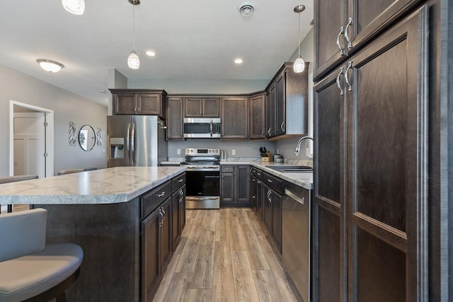 307 Brussels Ct, Marshall, MN 56258 - kitchen featuring appliances with stainless steel finishes, dark brown cabinets, light wood-type flooring, decorative light fixtures, and recessed lighting