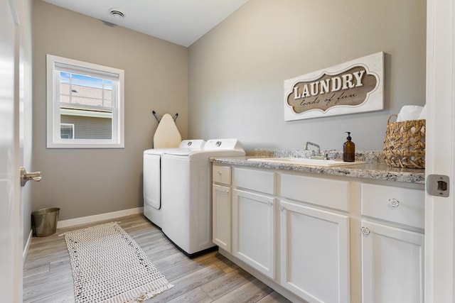 307 Brussels Ct, Marshall, MN 56258 - washroom featuring washer and clothes dryer, light wood finished floors, and cabinet space