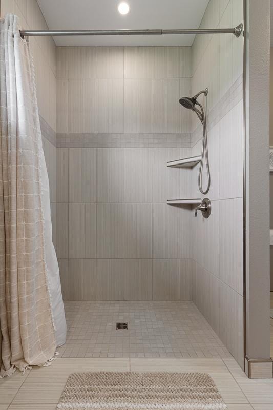 307 Brussels Ct, Marshall, MN 56258 - bathroom featuring tiled shower and tile patterned flooring