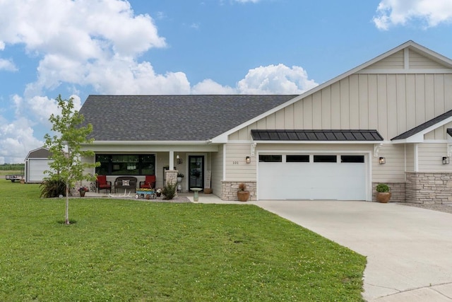 101 Butterfly Ct, Blue Earth, MN 56013 - view of front facade featuring board and batten siding, a front lawn, a garage, concrete driveway, and stone siding