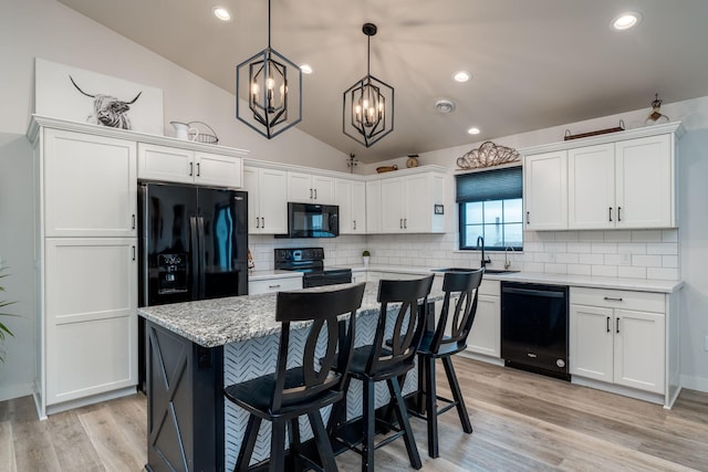 101 Butterfly Ct, Blue Earth, MN 56013 - kitchen with black appliances, a chandelier, white cabinets, vaulted ceiling, and decorative backsplash
