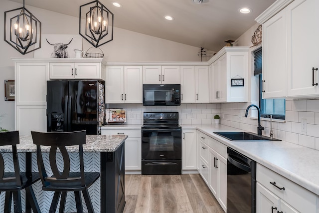 101 Butterfly Ct, Blue Earth, MN 56013 - kitchen featuring black appliances, vaulted ceiling, light countertops, light wood-style flooring, and white cabinetry
