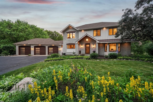 5705 Covington Cir, Minnetonka, MN 55345 - view of front of home with a garage, a front lawn, driveway, board and batten siding, and brick siding