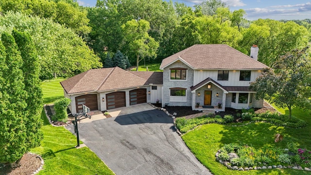 5705 Covington Cir, Minnetonka, MN 55345 - view of front of home with asphalt driveway, an attached garage, a chimney, and a front lawn