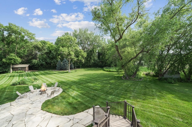 5705 Covington Cir, Minnetonka, MN 55345 - view of green lawn with a fire pit, a patio area, a deck, and view of scattered trees