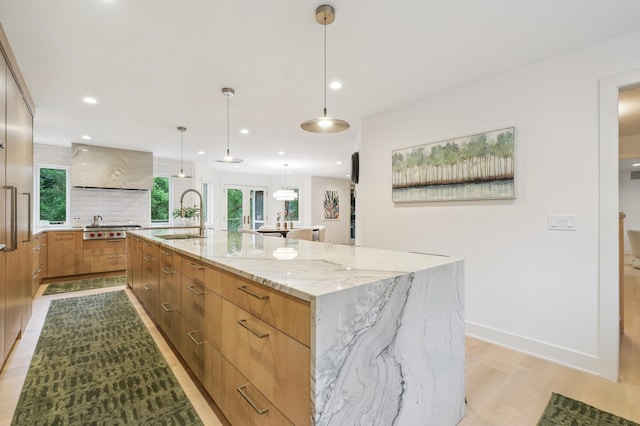 5705 Covington Cir, Minnetonka, MN 55345 - kitchen with stainless steel gas cooktop, modern cabinets, light wood-style flooring, light stone counters, and recessed lighting