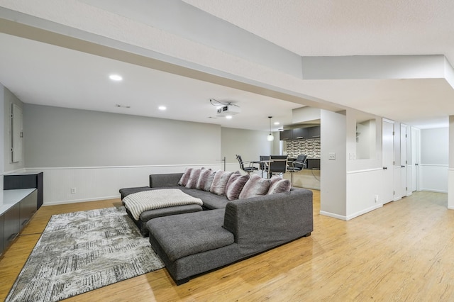 5705 Covington Cir, Minnetonka, MN 55345 - living room with light wood finished floors, a wainscoted wall, and recessed lighting