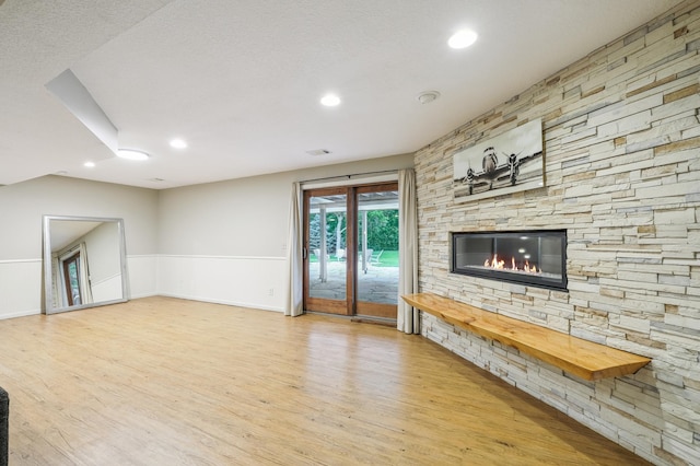 5705 Covington Cir, Minnetonka, MN 55345 - unfurnished living room featuring wood finished floors, a stone fireplace, a wainscoted wall, and recessed lighting