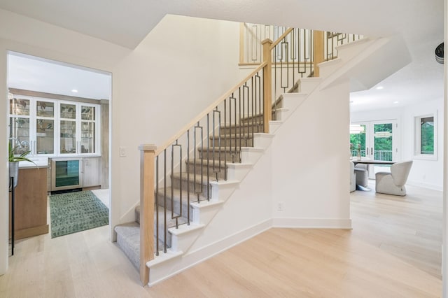 5705 Covington Cir, Minnetonka, MN 55345 - stairway featuring wine cooler, wood finished floors, and recessed lighting