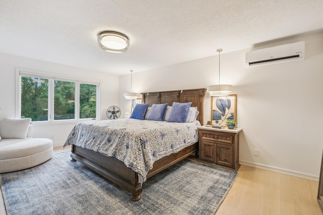 5705 Covington Cir, Minnetonka, MN 55345 - bedroom featuring a wall mounted AC, light wood-style flooring, and a textured ceiling