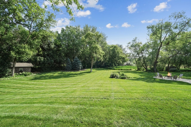 5705 Covington Cir, Minnetonka, MN 55345 - view of grassy yard with a fire pit, view of scattered trees, and a patio