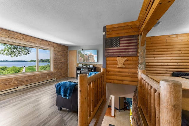 32873 Flanders St NE, Cambridge, MN 55008 - living room with a textured ceiling, wood finished floors, a baseboard radiator, and rustic walls