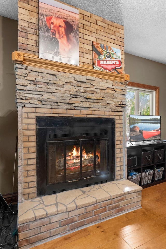 32873 Flanders St NE, Cambridge, MN 55008 - detailed view of a brick fireplace, a textured ceiling, and wood finished floors