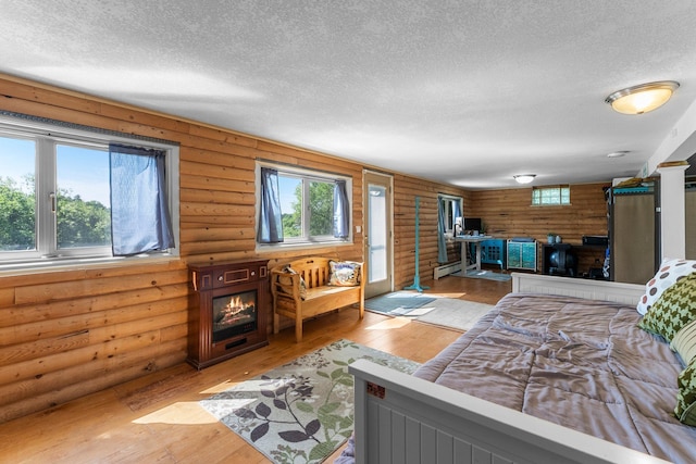 32873 Flanders St NE, Cambridge, MN 55008 - bedroom featuring a textured ceiling, log walls, light wood-type flooring, and a fireplace