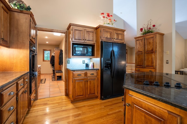 8980 160th Ln NW, Ramsey, MN 55303 - kitchen featuring black appliances, brown cabinetry, light wood-style flooring, and high vaulted ceiling