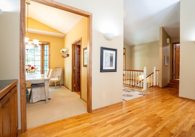 8980 160th Ln NW, Ramsey, MN 55303 - hallway featuring vaulted ceiling, an upstairs landing, a chandelier, and light wood-style floors