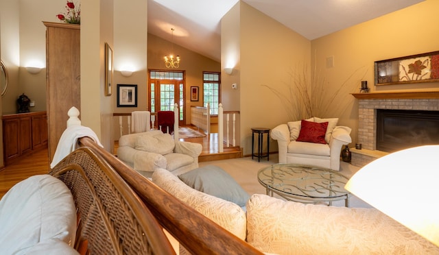8980 160th Ln NW, Ramsey, MN 55303 - living area featuring a chandelier, lofted ceiling, a brick fireplace, and wood finished floors