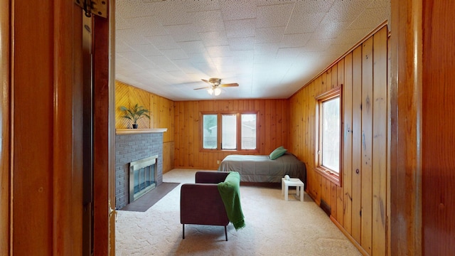 507 Hawthorne St, Albert Lea, MN 56007 - bedroom with light colored carpet, a brick fireplace, wood walls, and ceiling fan