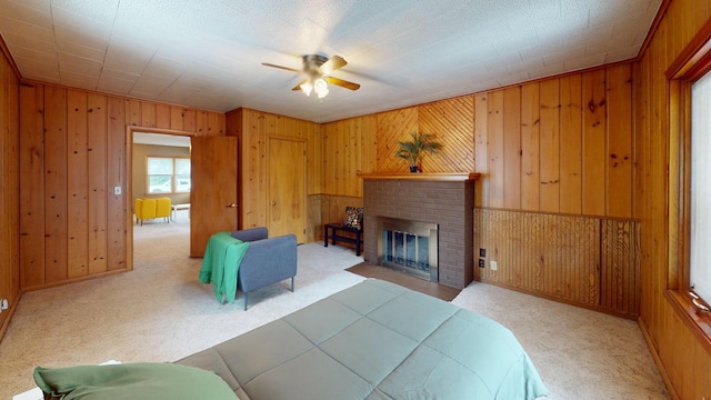 507 Hawthorne St, Albert Lea, MN 56007 - carpeted bedroom featuring wood walls, a brick fireplace, and a ceiling fan