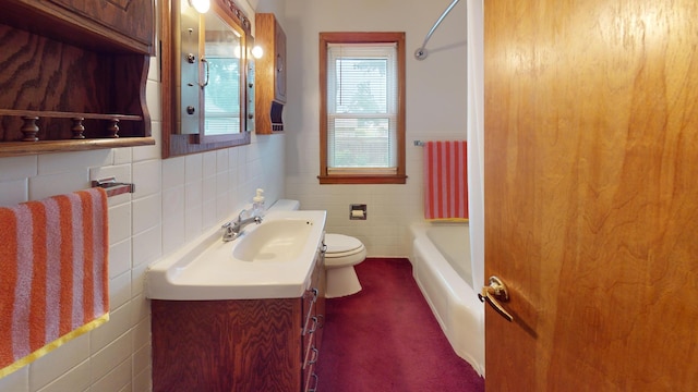 507 Hawthorne St, Albert Lea, MN 56007 - bathroom with tile walls, vanity, a wainscoted wall, and washtub / shower combination