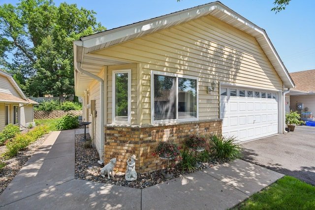 1021 18th Ave SE, Forest Lake, MN 55025 - view of front facade with brick siding, asphalt driveway, and a garage