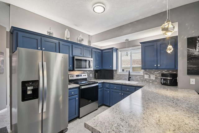 1021 18th Ave SE, Forest Lake, MN 55025 - kitchen featuring appliances with stainless steel finishes, blue cabinetry, decorative backsplash, pendant lighting, and light countertops