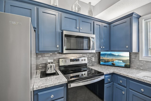 1021 18th Ave SE, Forest Lake, MN 55025 - kitchen with appliances with stainless steel finishes, blue cabinetry, and backsplash