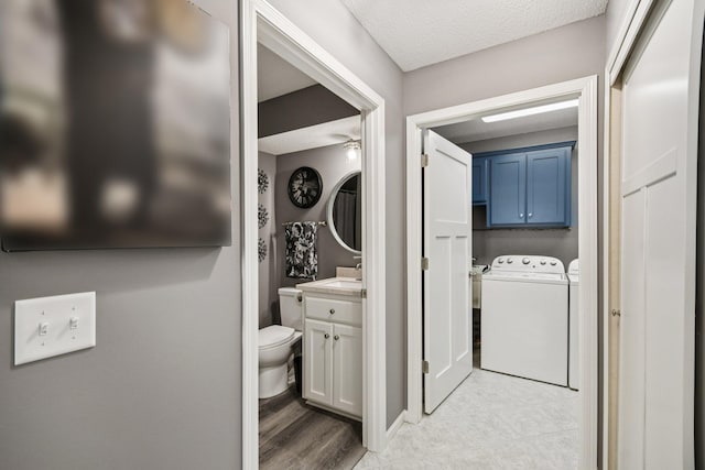 1021 18th Ave SE, Forest Lake, MN 55025 - bathroom featuring separate washer and dryer, vanity, a textured ceiling, and ceiling fan