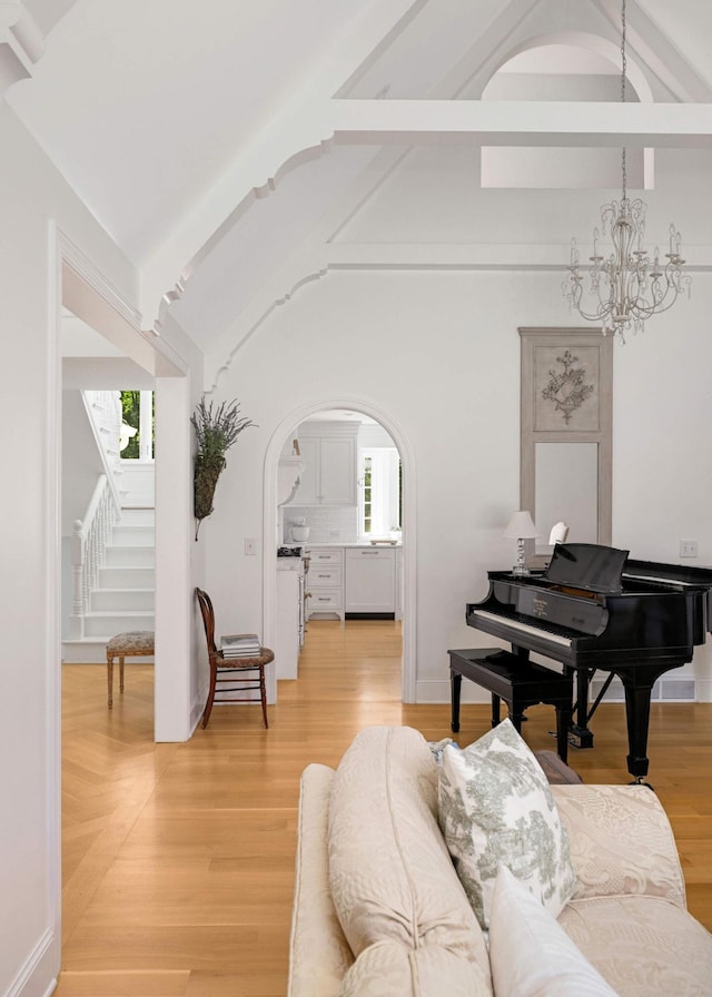 2255 French Creek Cir, Orono, MN 55391 - living area with arched walkways, a chandelier, stairway, and light wood-style flooring