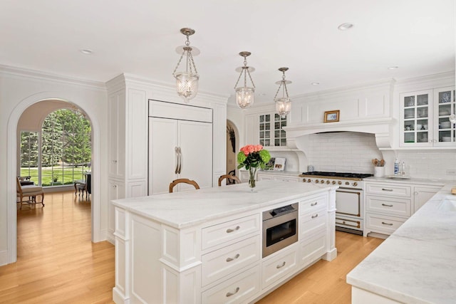 2255 French Creek Cir, Orono, MN 55391 - kitchen featuring premium appliances, backsplash, a kitchen island, white cabinetry, and recessed lighting
