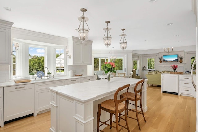 2255 French Creek Cir, Orono, MN 55391 - kitchen featuring a chandelier, tasteful backsplash, a kitchen island, light wood finished floors, and recessed lighting