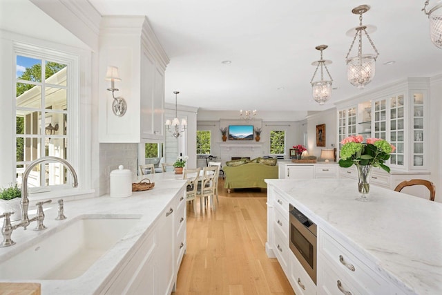 2255 French Creek Cir, Orono, MN 55391 - kitchen featuring a chandelier, stainless steel microwave, light wood finished floors, white cabinets, and recessed lighting