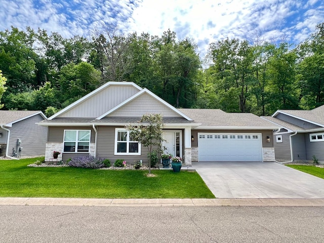 1180 Hewitt Blvd, Red Wing, MN 55066 - view of front of property with stone siding, an attached garage, a front lawn, and concrete driveway