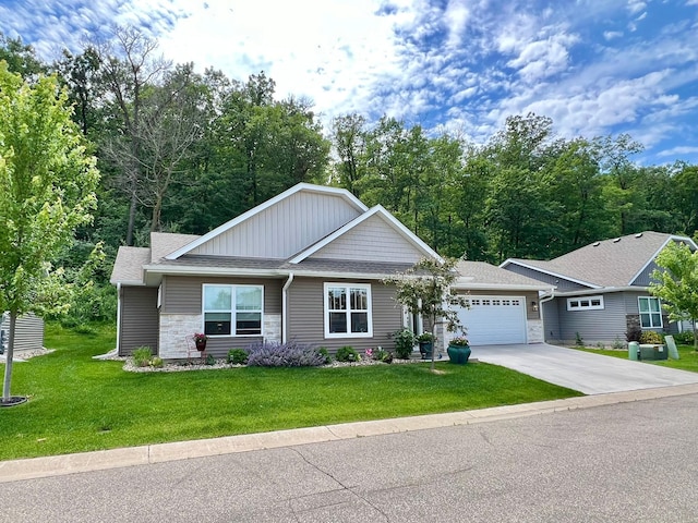 1180 Hewitt Blvd, Red Wing, MN 55066 - view of front of home featuring stone siding, an attached garage, a front yard, concrete driveway, and a shingled roof