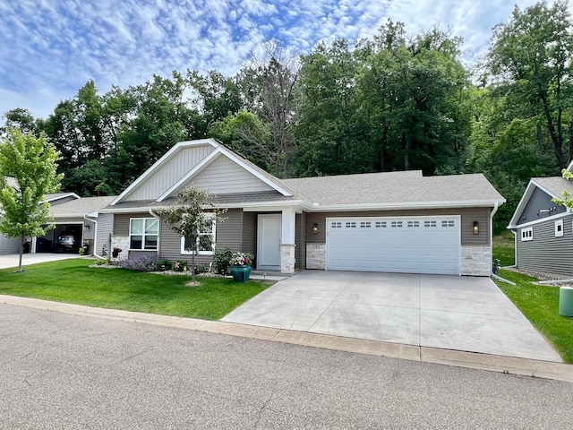 1180 Hewitt Blvd, Red Wing, MN 55066 - view of front of property featuring stone siding, a front yard, an attached garage, and concrete driveway
