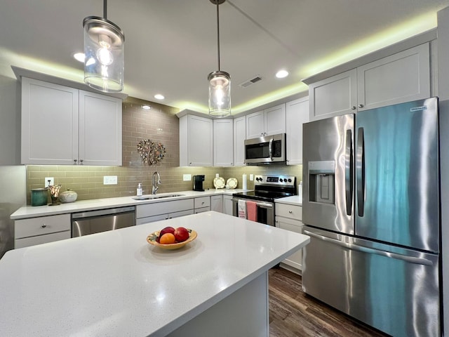 1180 Hewitt Blvd, Red Wing, MN 55066 - kitchen with stainless steel appliances, light countertops, tasteful backsplash, dark wood-style flooring, and decorative light fixtures