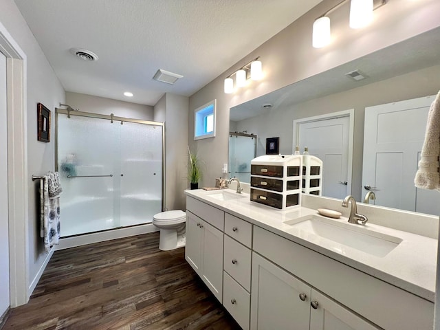 1180 Hewitt Blvd, Red Wing, MN 55066 - full bathroom featuring wood finished floors, a shower stall, double vanity, and a textured ceiling