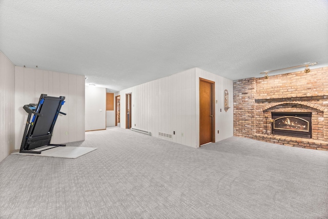 70190 218th St, Dassel, MN 55325 - unfurnished living room featuring a fireplace, a baseboard radiator, carpet flooring, and a textured ceiling