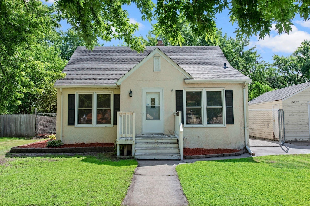 5532 Knox Ave N, Brooklyn Center, MN 55430 - view of front of home with stucco siding, roof with shingles, and a gate