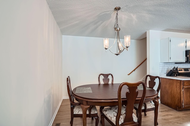 960 106th Ln NW Unit 22, Coon Rapids, MN 55433 - dining area featuring a chandelier, a textured ceiling, and light wood-type flooring