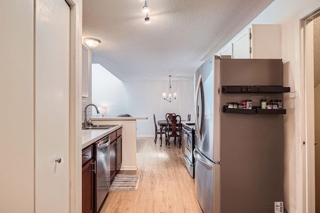 960 106th Ln NW Unit 22, Coon Rapids, MN 55433 - kitchen featuring stainless steel appliances, light wood finished floors, a textured ceiling, a chandelier, and light countertops