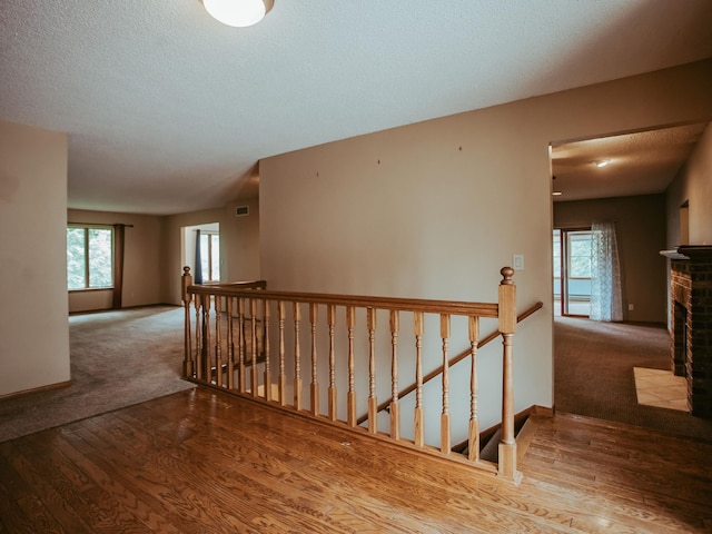 610 25th St SW, Austin, MN 55912 - hallway featuring an upstairs landing, carpet flooring, wood finished floors, and a textured ceiling