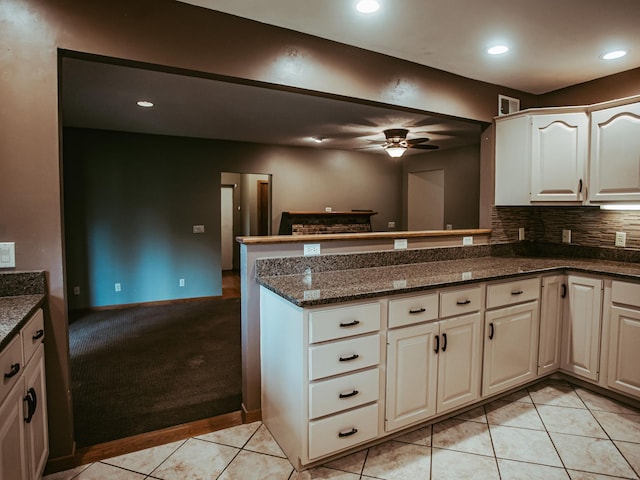 610 25th St SW, Austin, MN 55912 - kitchen with a peninsula, a ceiling fan, dark stone counters, backsplash, and recessed lighting