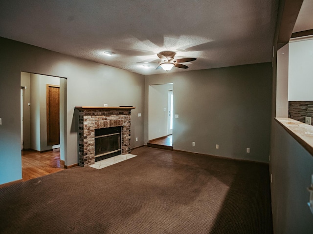 610 25th St SW, Austin, MN 55912 - unfurnished living room featuring a fireplace, a ceiling fan, carpet flooring, and a textured ceiling