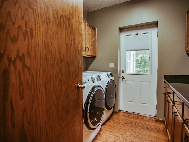 610 25th St SW, Austin, MN 55912 - laundry room featuring cabinet space, washing machine and dryer, light wood-type flooring, and a textured ceiling