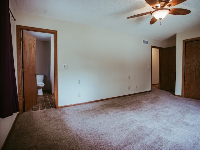 610 25th St SW, Austin, MN 55912 - unfurnished bedroom featuring carpet floors, a textured ceiling, ensuite bathroom, and ceiling fan