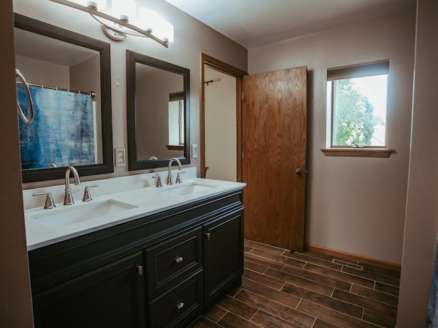 610 25th St SW, Austin, MN 55912 - bathroom featuring double vanity and wood finished floors